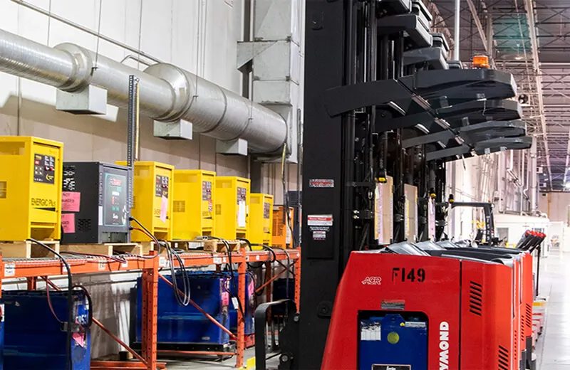 Powered material handling equipment lined up at charging station in MTE Logistix Edmonton warehouse