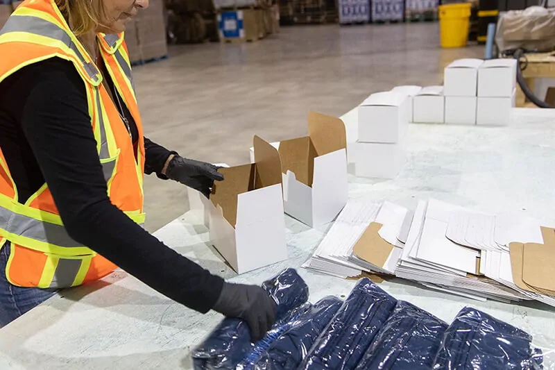 Item insertion in order fulfillment and copacking area at an MTE Logistix warehouse facility