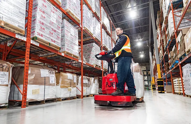 Certified MTE Logistix employee operating powered material handling equipment to move product in an MTE warehouse