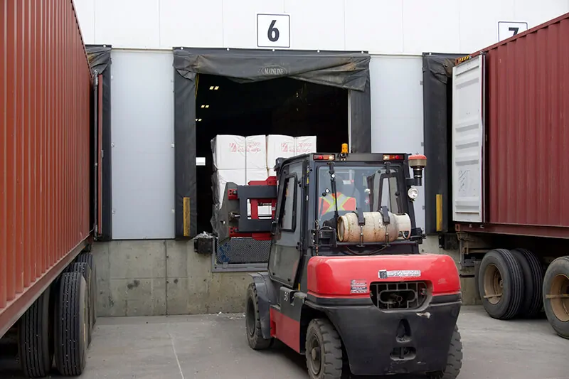 Loading pulp through bay door with forklift for storage at MTE Logistix warehouse